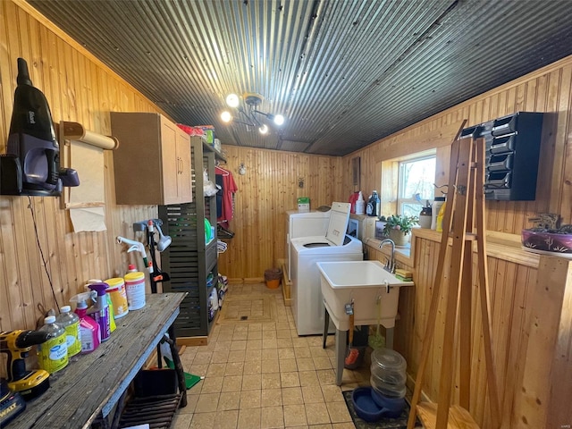 interior space featuring separate washer and dryer, wood walls, and sink