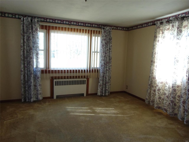 carpeted spare room featuring radiator