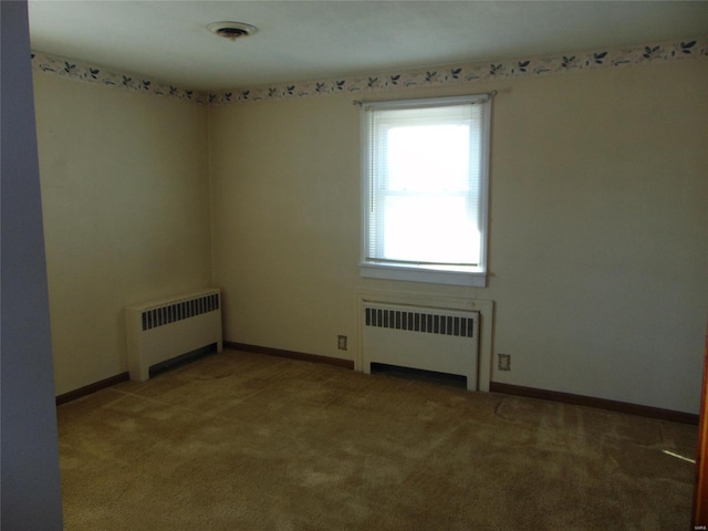 carpeted empty room featuring radiator