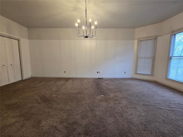 unfurnished dining area featuring baseboards, carpet floors, and a chandelier