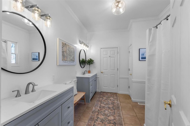 full bath featuring crown molding, two vanities, and a sink