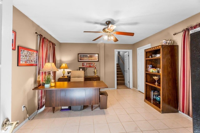 office space with baseboards, light tile patterned flooring, and a ceiling fan