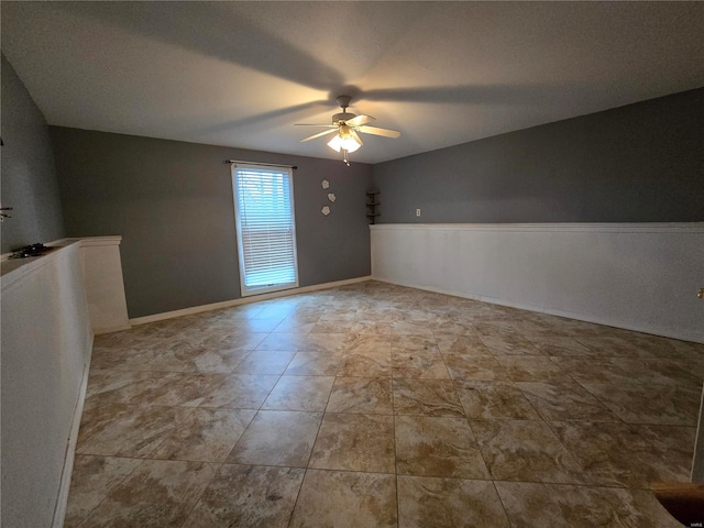 spare room with baseboards and a ceiling fan