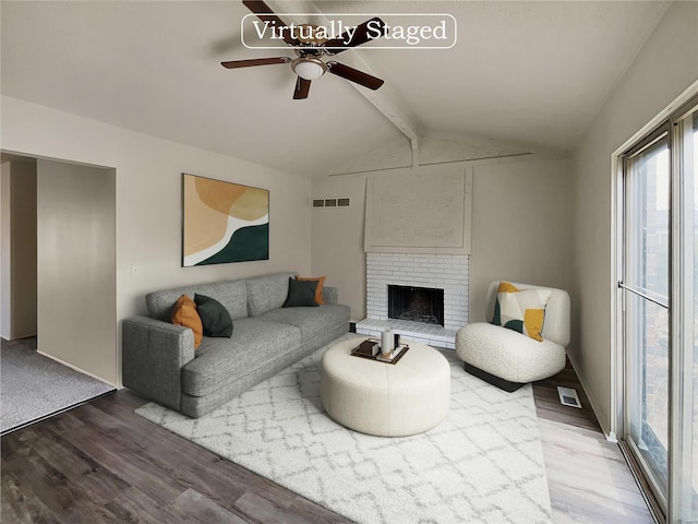 living room featuring ceiling fan, lofted ceiling, hardwood / wood-style floors, and a brick fireplace