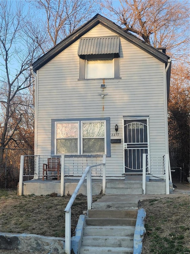 rear view of property featuring covered porch