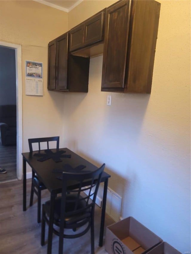 dining room featuring dark hardwood / wood-style floors and crown molding