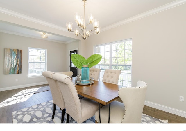 dining space featuring ornamental molding, wood-type flooring, and a chandelier