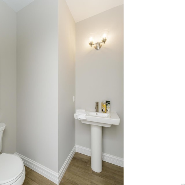 bathroom with hardwood / wood-style floors and toilet