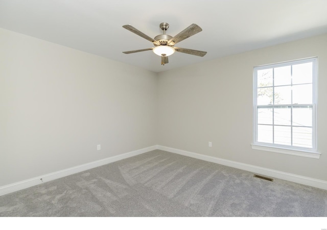 unfurnished room with plenty of natural light, ceiling fan, and carpet