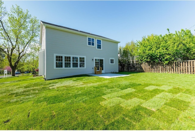 back of property featuring a lawn and a patio area