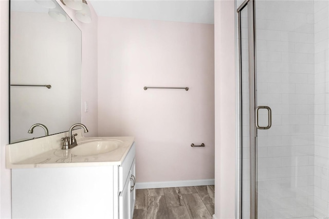 bathroom featuring hardwood / wood-style flooring, vanity, and a shower with door