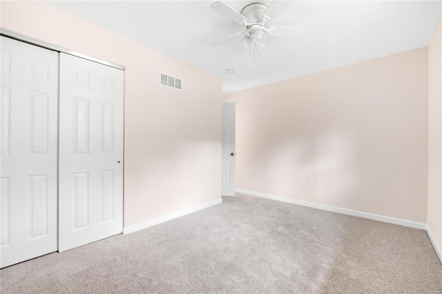 unfurnished bedroom with ceiling fan, a closet, and light colored carpet