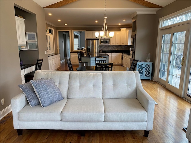 living room with ornamental molding, hardwood / wood-style floors, and a chandelier