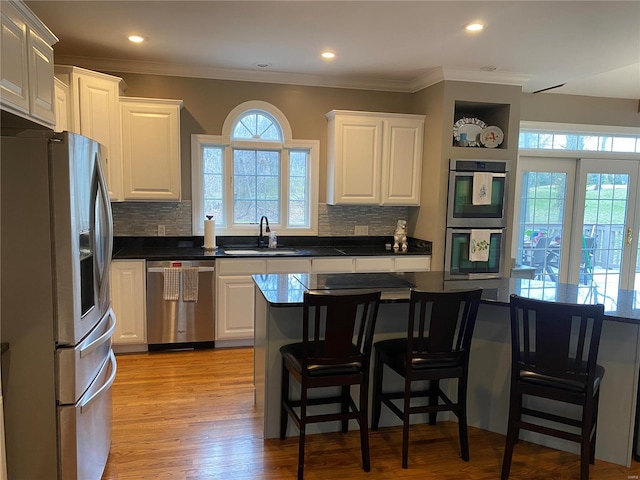 kitchen featuring light hardwood / wood-style flooring, sink, stainless steel appliances, and backsplash