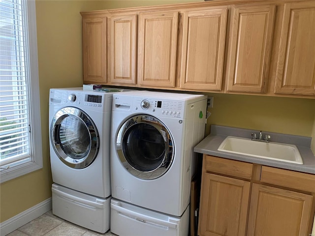 clothes washing area with cabinets, independent washer and dryer, light tile floors, and sink