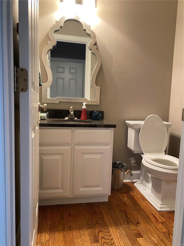 bathroom featuring oversized vanity, wood-type flooring, and toilet