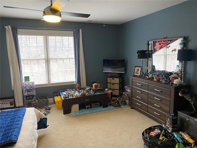 bedroom featuring multiple windows, ceiling fan, and light colored carpet