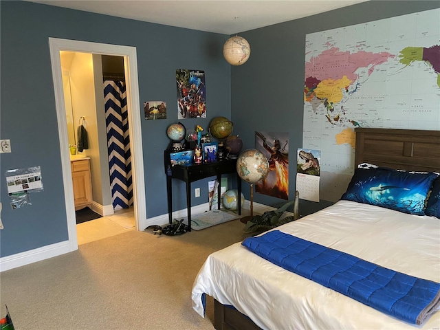 bedroom featuring light colored carpet and ensuite bathroom