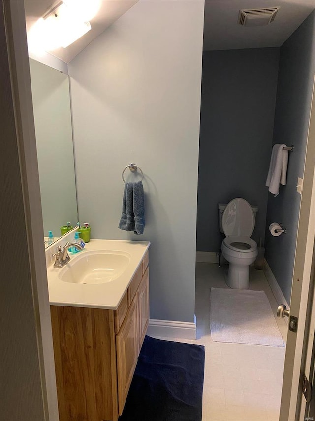 bathroom with tile floors, toilet, and vanity