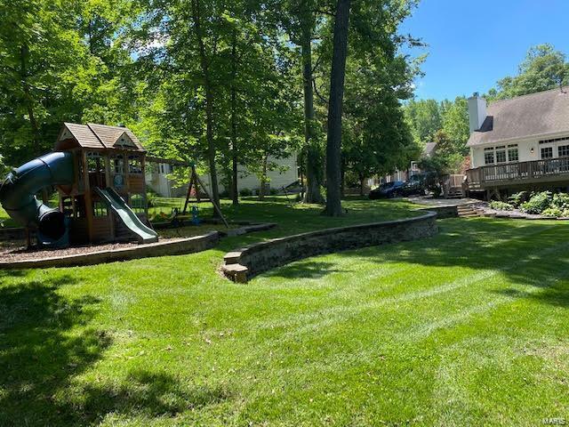 view of yard featuring a wooden deck and a playground