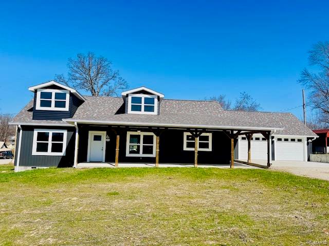 view of front of house featuring a porch, a front lawn, and a garage