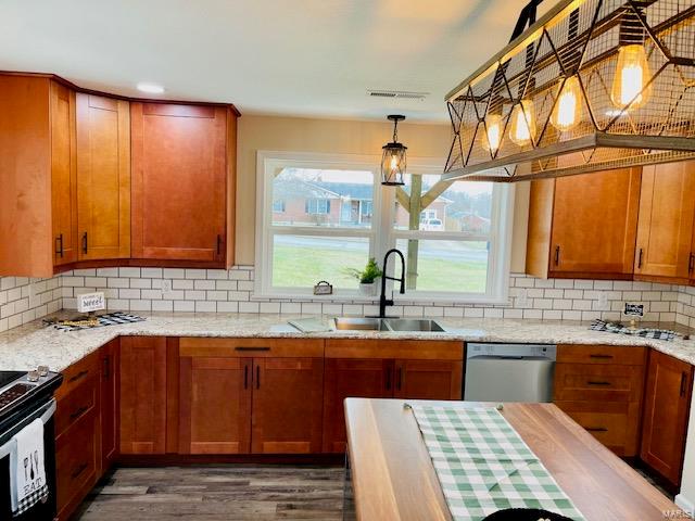 kitchen with tasteful backsplash, stainless steel dishwasher, and light stone counters