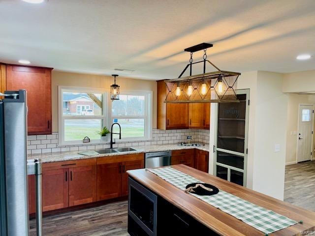 kitchen featuring backsplash, pendant lighting, dark hardwood / wood-style flooring, and sink