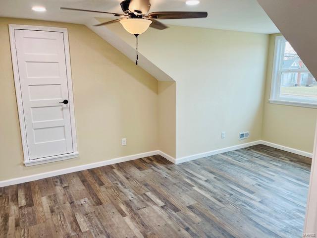 bonus room with dark hardwood / wood-style floors, vaulted ceiling, and ceiling fan