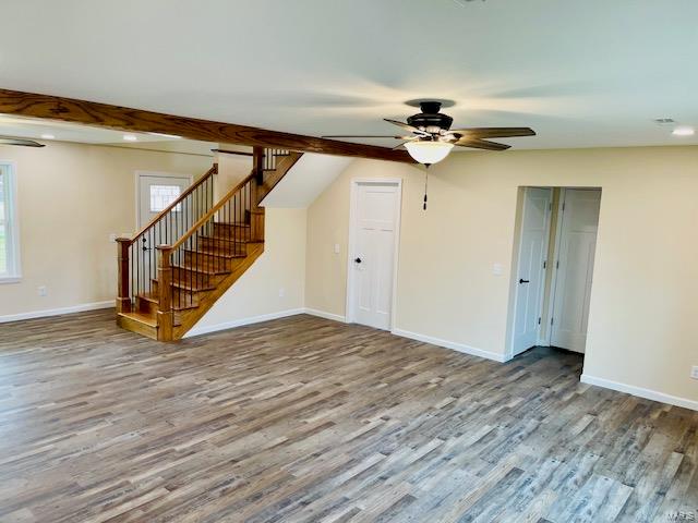 interior space featuring ceiling fan, beam ceiling, and wood-type flooring