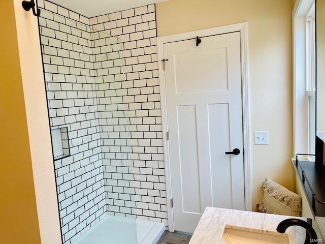 bathroom with vanity and tiled shower