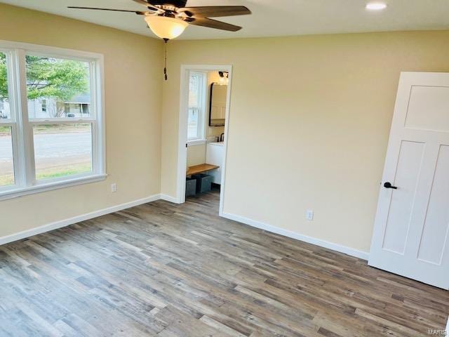 unfurnished bedroom featuring dark hardwood / wood-style flooring, ceiling fan, and ensuite bathroom