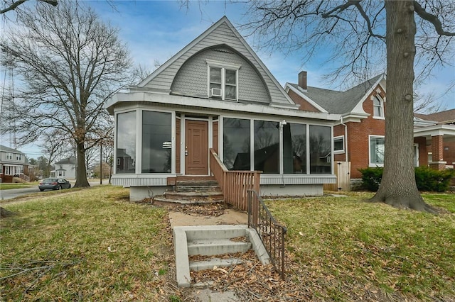 view of front of property featuring a front yard and a sunroom