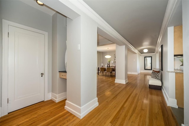 hallway featuring light hardwood / wood-style floors and ornamental molding