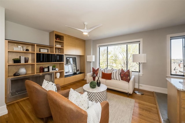 living room with ceiling fan and light hardwood / wood-style flooring