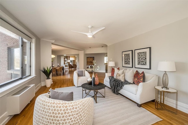 living room featuring ceiling fan, radiator heating unit, and light hardwood / wood-style floors