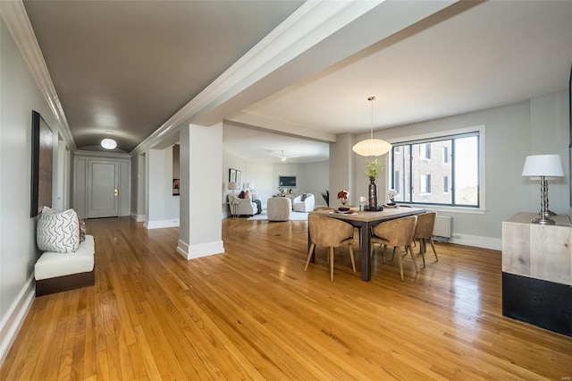 dining space featuring radiator heating unit, light wood-type flooring, and baseboards