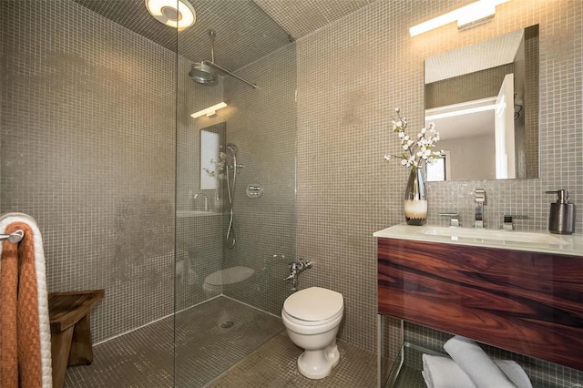 bathroom featuring decorative backsplash, a tile shower, vanity, and tile walls