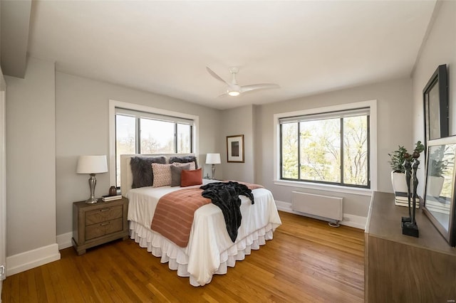 bedroom with ceiling fan, hardwood / wood-style flooring, and radiator