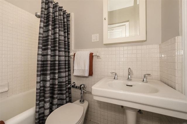 full bathroom featuring shower / tub combo, a wainscoted wall, tile walls, and toilet