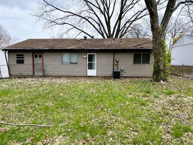 rear view of house featuring a yard