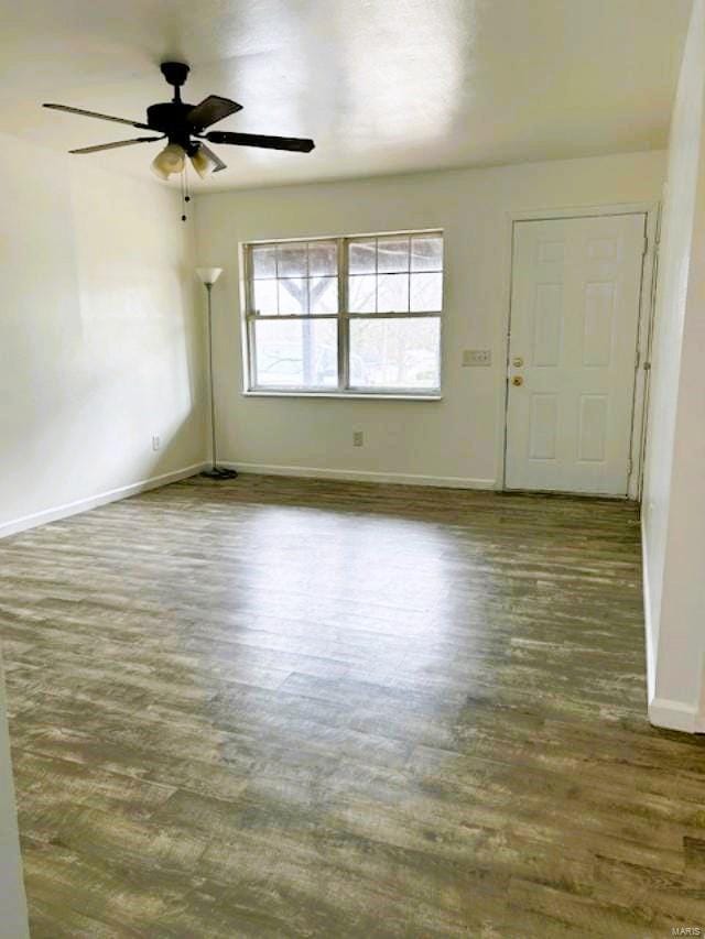 empty room with ceiling fan and dark wood-type flooring