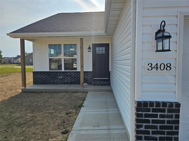 view of exterior entry featuring covered porch