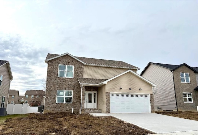 front facade featuring central AC and a garage