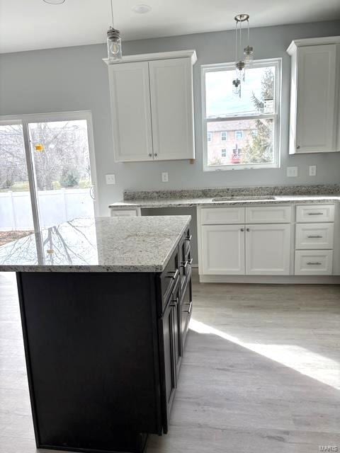 kitchen with white cabinetry, pendant lighting, and a wealth of natural light