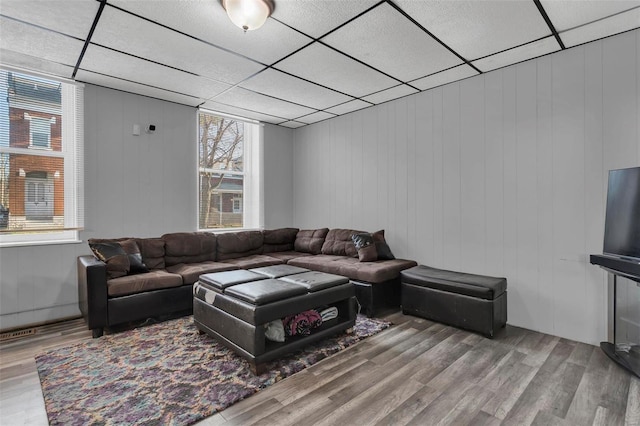 living room with wood-type flooring and a drop ceiling