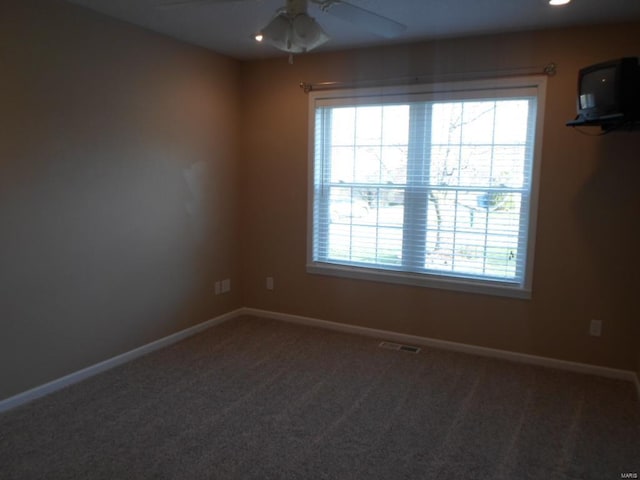 spare room featuring carpet floors and ceiling fan