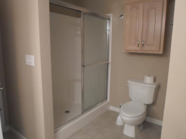 bathroom featuring toilet, tile flooring, and walk in shower