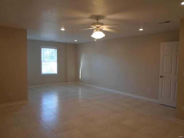 tiled spare room with ceiling fan