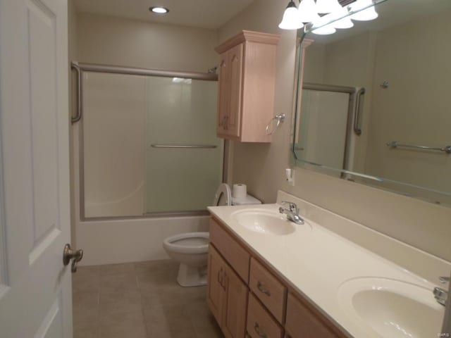 full bathroom with tile flooring, double sink, bath / shower combo with glass door, toilet, and oversized vanity