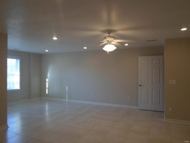 tiled spare room featuring ceiling fan